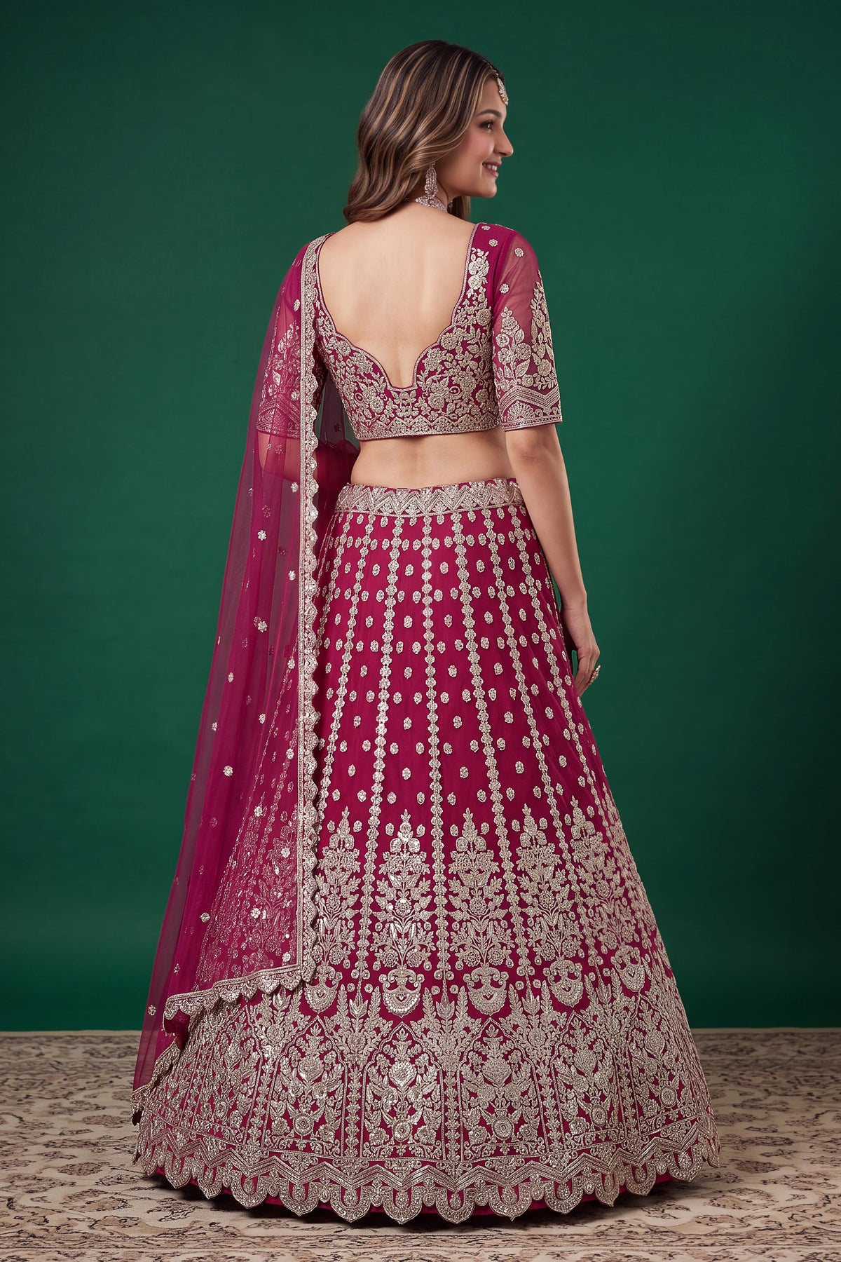 Alternate view of a hot pink party wear lehenga in net with zari, dori and sequins work on the sleeveless blouse and lehenga.