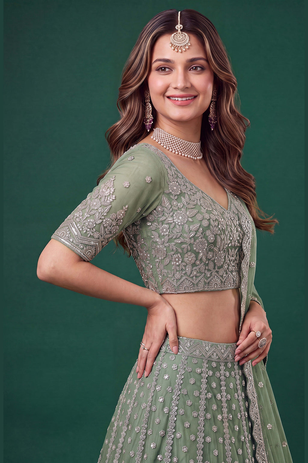 Full-length back view of a pista mehndi outfits lehenga in net with an open back blouse with dori tie and zari and sequins work.