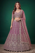 Woman wearing a light purple sangeet lehenga in net with zari, dori and sequins work, sleeveless sweetheart blouse, full-length front view.