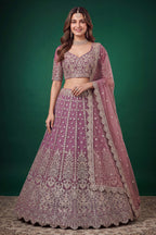 Woman wearing a light purple sangeet lehenga in net with zari, dori and sequins work, sleeveless sweetheart blouse, full-length front view.