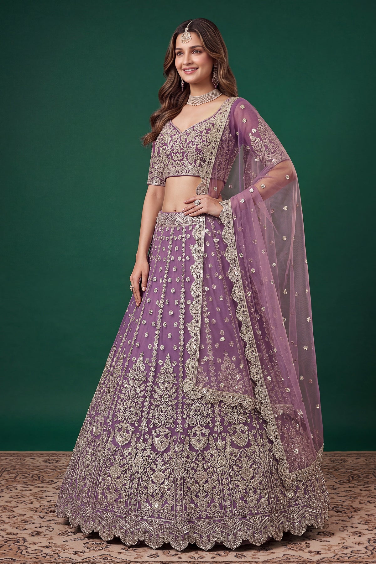 Seated view of a light purple engagement lehenga in net with zari, dori and sequins work on the sleeveless blouse and lehenga.