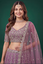 Full-length side view of a light purple engagement dresses for women lehenga in net with zari, dori and sequins work on the flared skirt.