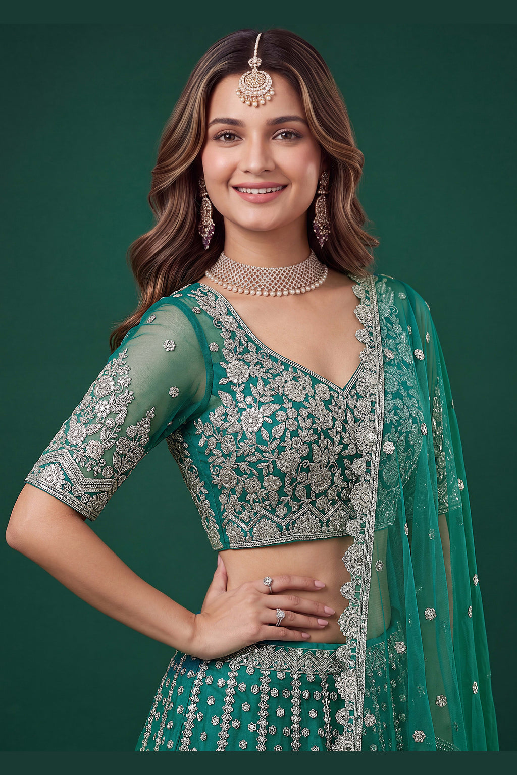 Full-length side view of a teal engagement dresses for women lehenga in net with zari, dori and sequins work on the flared skirt.