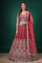 Woman wearing a red lehenga for wedding in net with zari, dori and sequins work, sleeveless sweetheart blouse, full-length front view.
