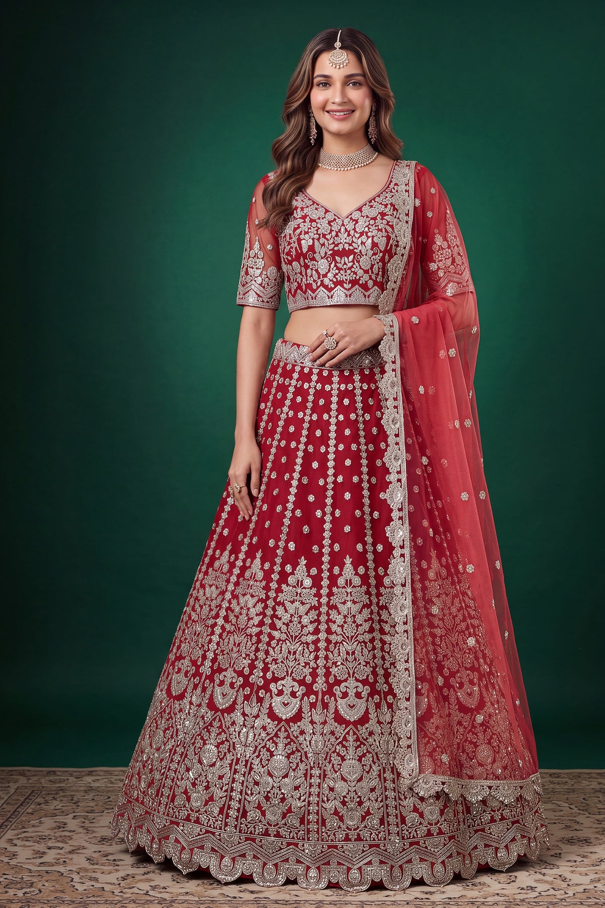 Woman wearing a red lehenga for wedding in net with zari, dori and sequins work, sleeveless sweetheart blouse, full-length front view.