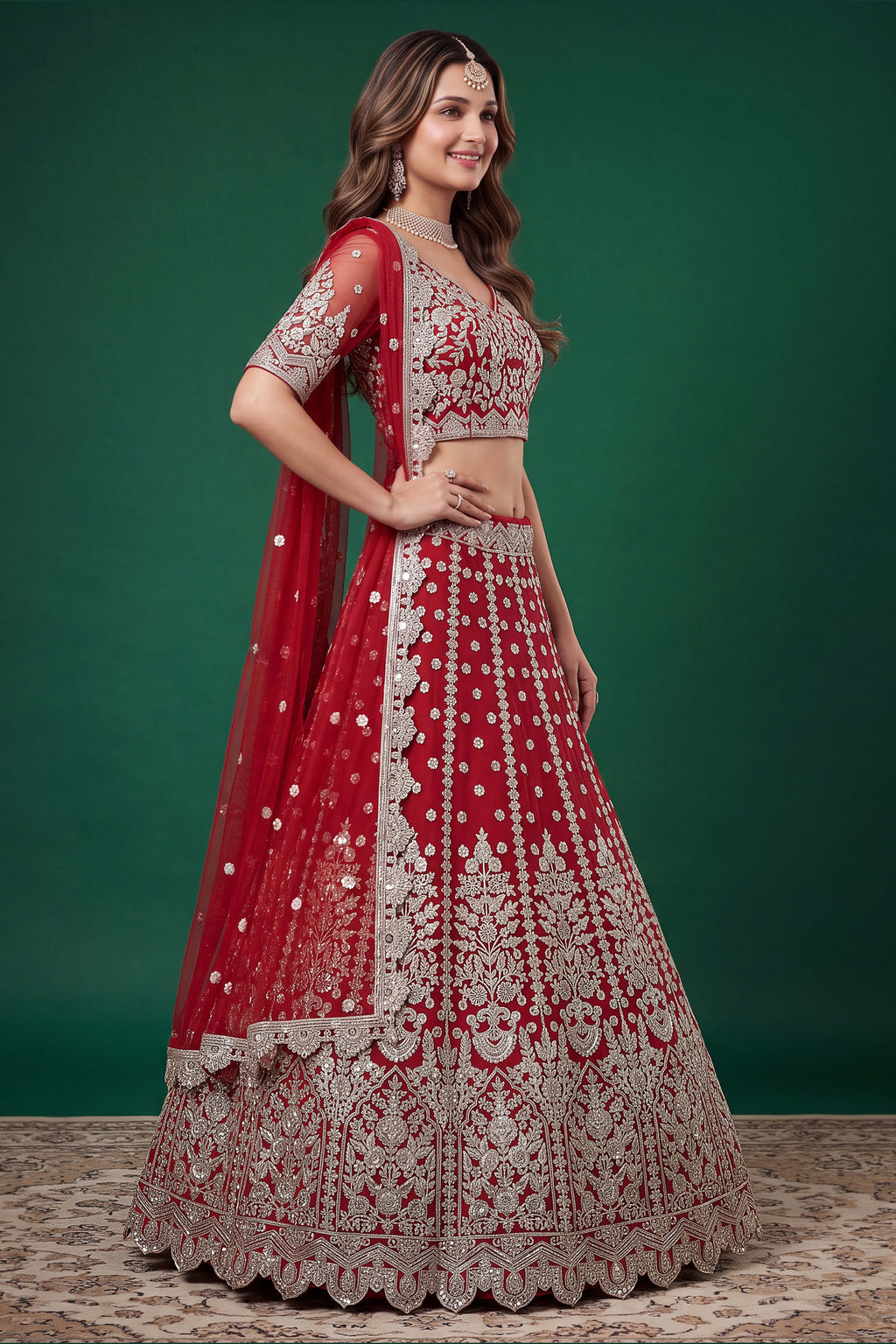 Full-length side view of a red engagement dresses for women lehenga in net with zari, dori and sequins work on the flared skirt.