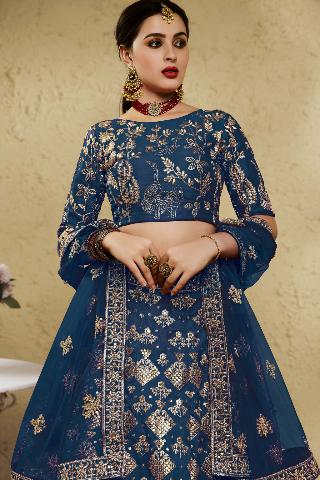 Close-up view of a blue sangeet lehenga in art silk with detailed zari and sequin embroidery work on the blouse and lehenga skirt.