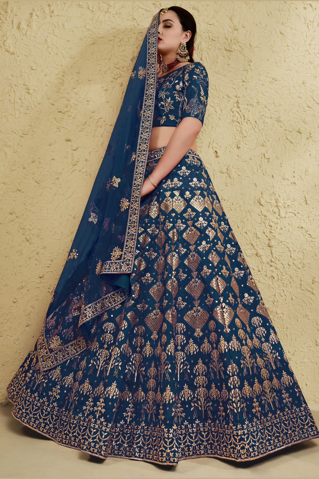 Full-length side view of a blue reception lehenga in art silk with zari and sequin embroidery work on the flared lehenga skirt.