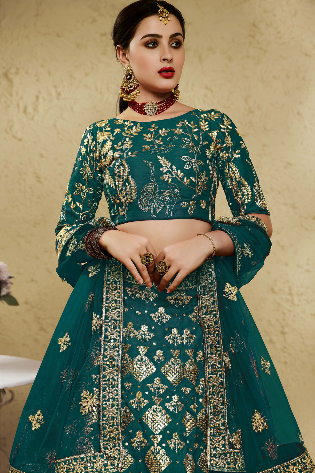 Close-up view of a green mehndi outfits lehenga in art silk with detailed zari and sequin embroidery work on the blouse and lehenga skirt.