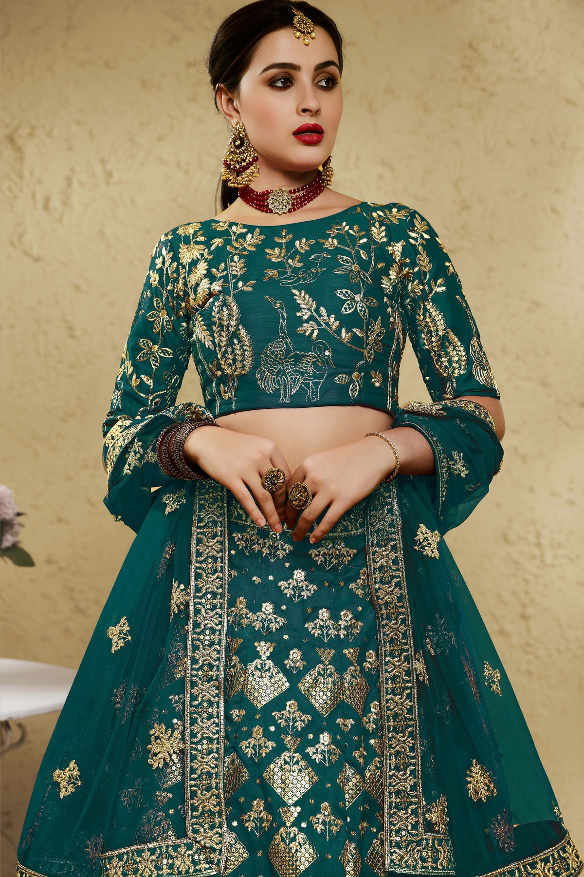 Close-up view of a green mehndi outfits lehenga in art silk with detailed zari and sequin embroidery work on the blouse and lehenga skirt.