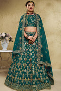 Woman wearing a green mehndi outfits lehenga in art silk with zari and sequin embroidery, half sleeve boat neck blouse, full-length front view.