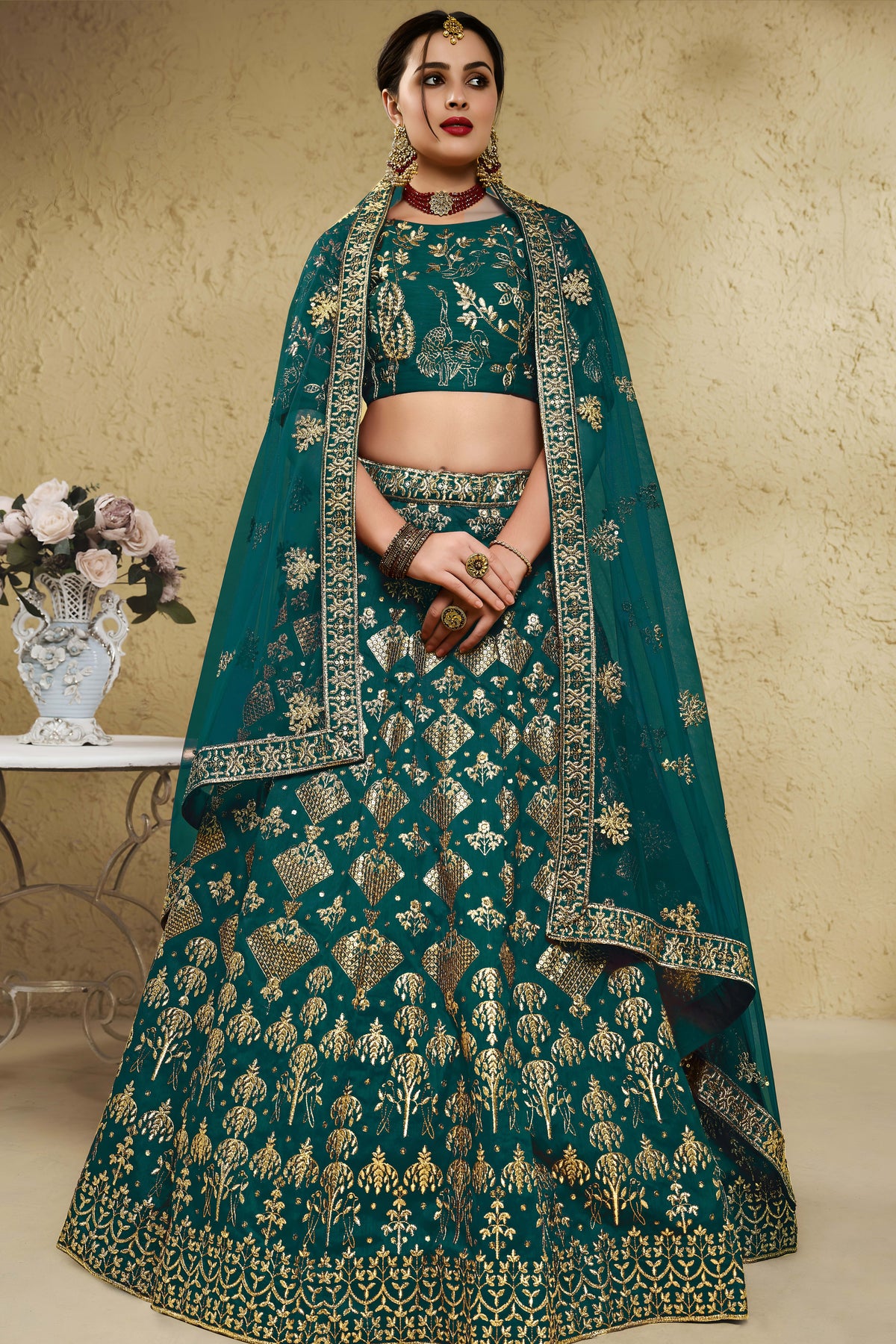 Woman wearing a green mehndi outfits lehenga in art silk with zari and sequin embroidery, half sleeve boat neck blouse, full-length front view.