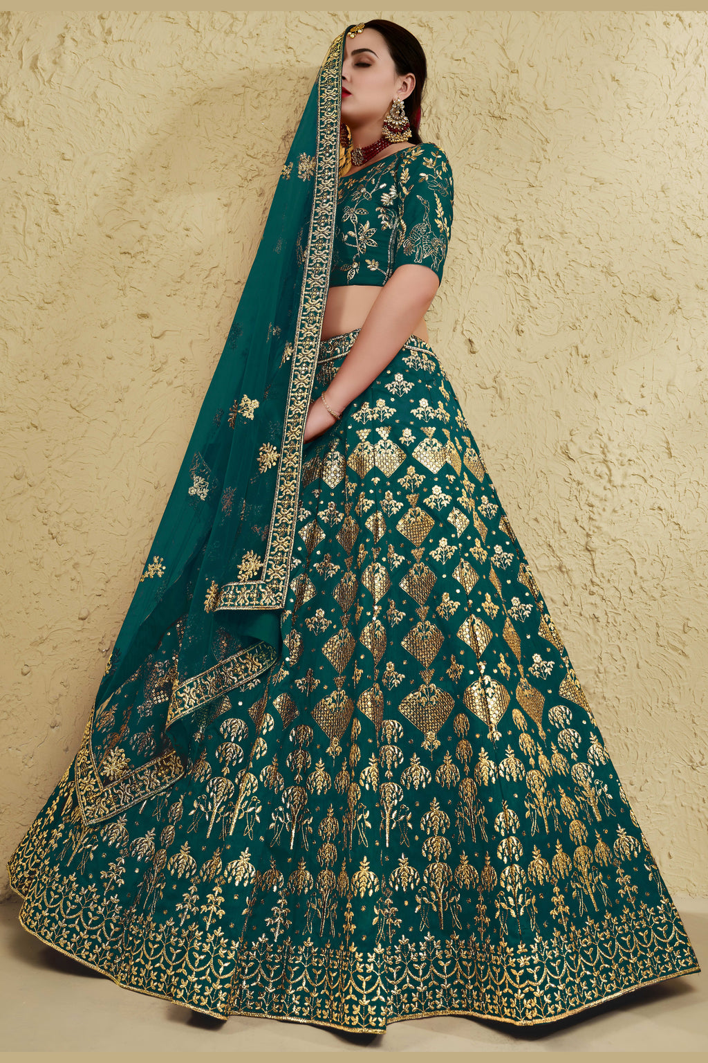 Full-length side view of a green engagement dresses for women lehenga in art silk with zari and sequin embroidery work on the flared skirt.