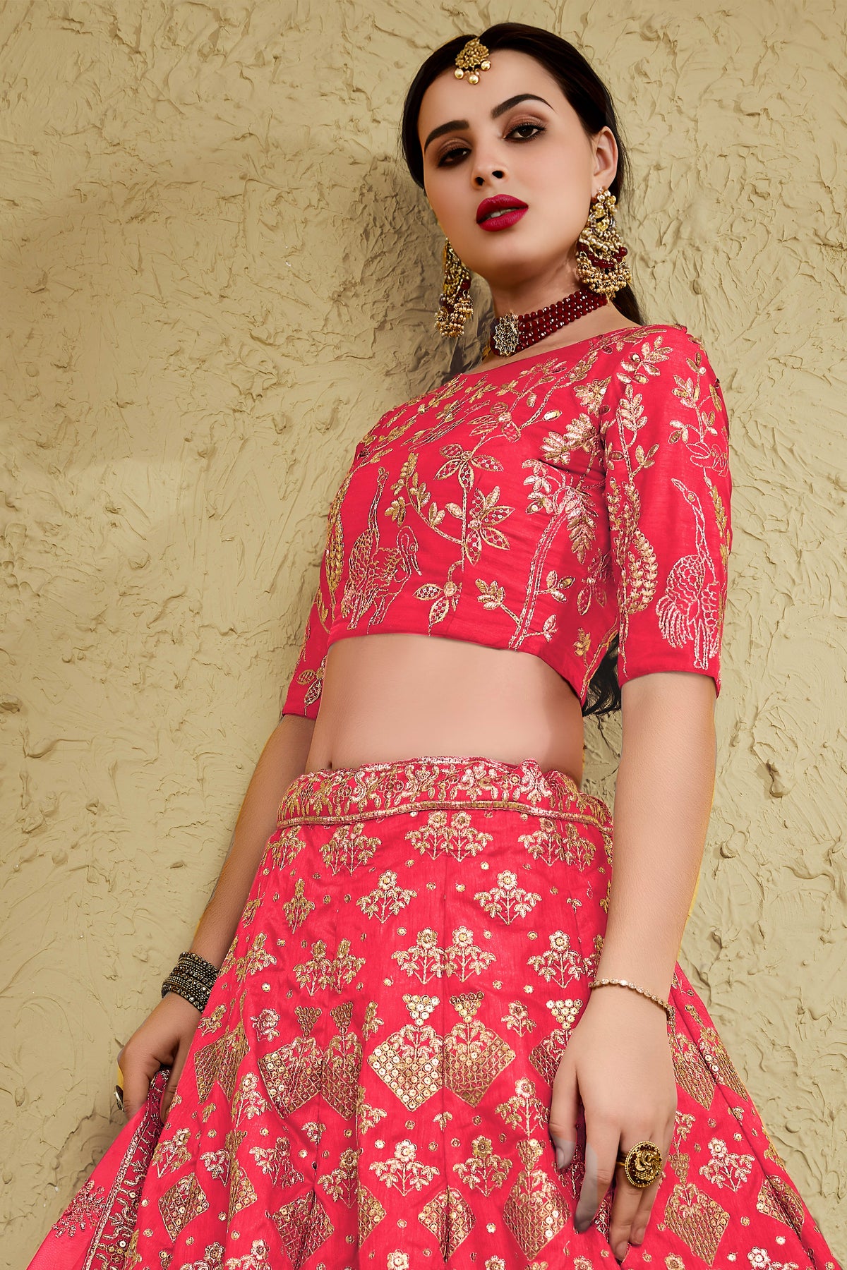 Alternate full-length view of a pinkish red reception lehenga in art silk with zari and sequin embroidery work on the blouse and lehenga.