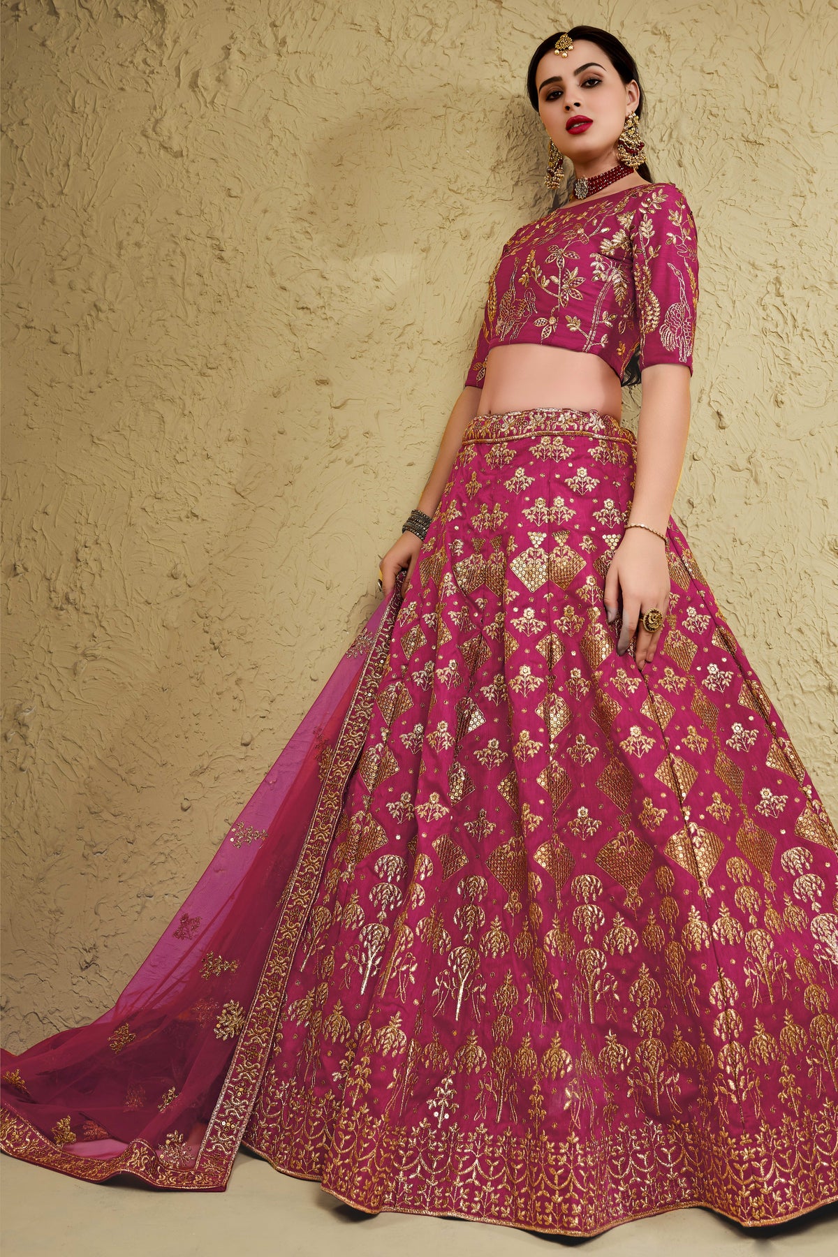Alternate full-length view of a dark pink party wear lehenga in art silk with zari and sequin embroidery work on the blouse and lehenga.
