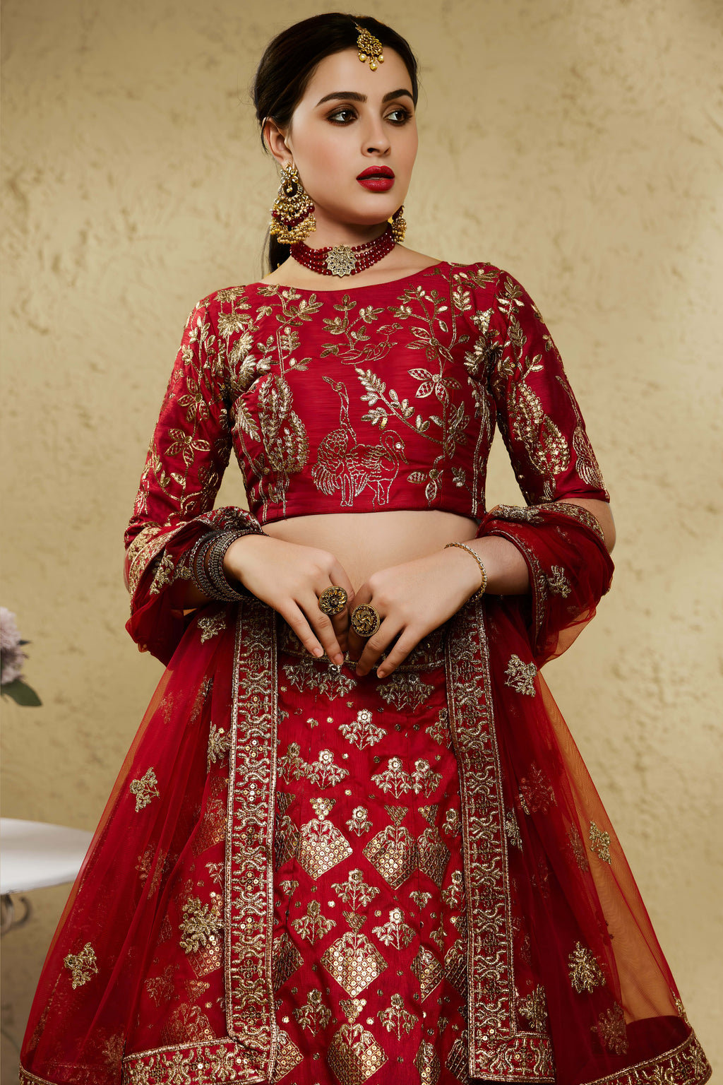Close-up view of a red engagement lehenga in art silk with detailed zari and sequin embroidery work on the blouse and lehenga skirt.