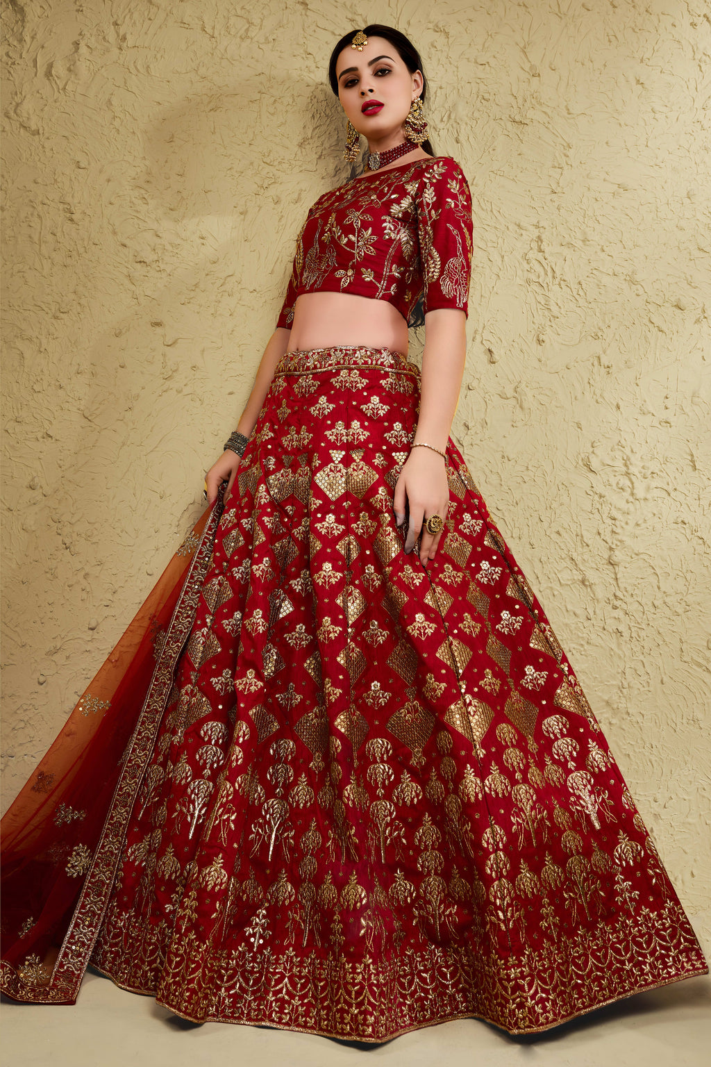 Full-length side view of a red engagement dresses for women lehenga in art silk with zari and sequin embroidery work on the flared skirt.