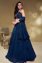 Full-length side view of a blue reception lehenga in georgette with zari, dori and sequin work on the flared lehenga skirt.