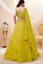 Full-length back view of a bright yellow haldi outfits lehenga in georgette with an open back blouse with dori tie and zari and sequin work.