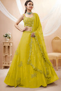 Woman wearing a bright yellow haldi outfits lehenga in georgette with zari, dori and sequin work, sleeveless sweetheart blouse, full-length front view.