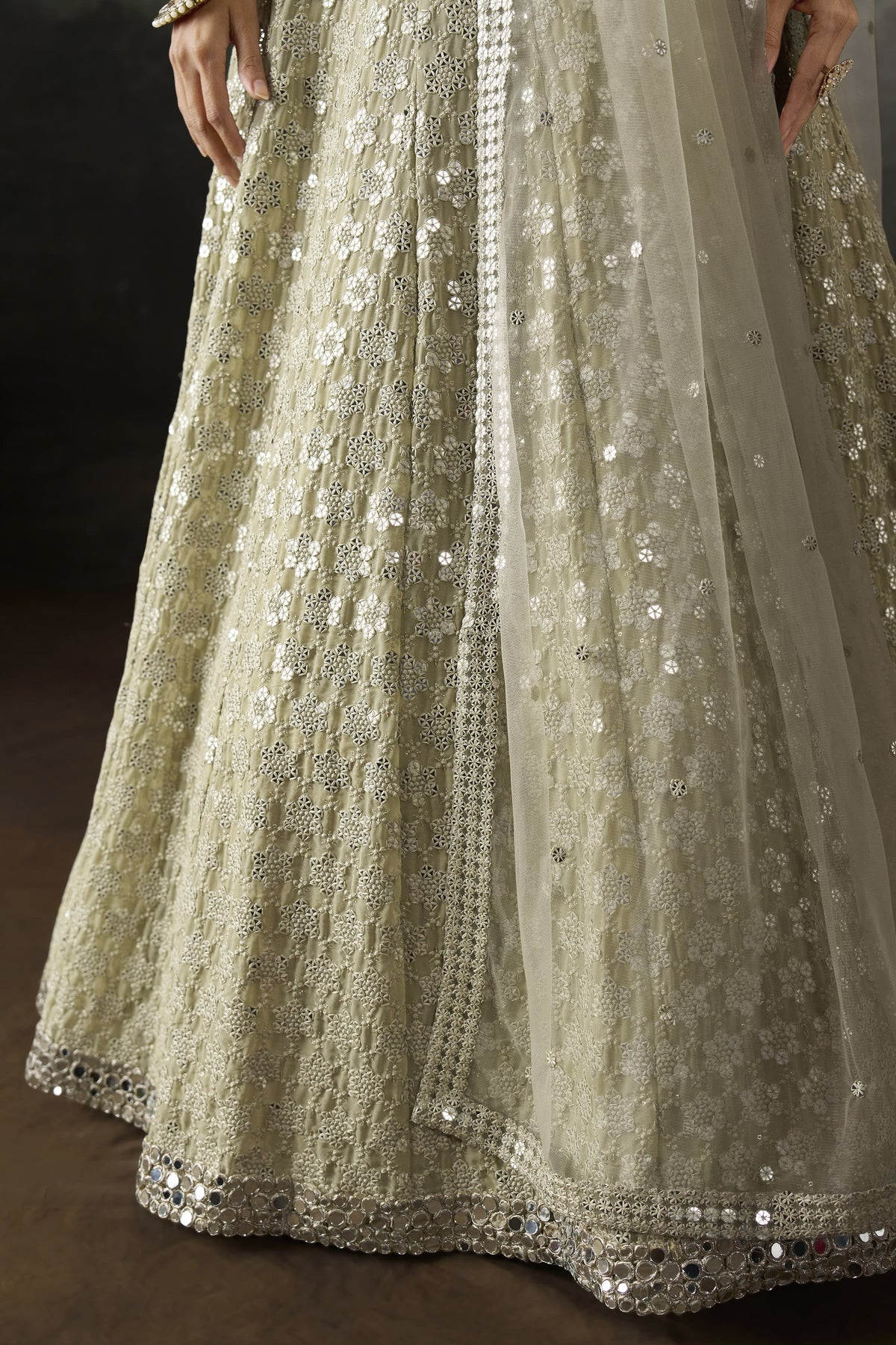Close-up of the champagne sequin lehenga skirt with dense sequin and mirror work on georgette and the sheer net dupatta edge.