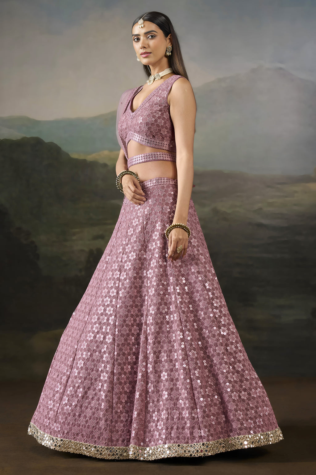 Side view of the baby pink sangeet attire showing the flared georgette skirt, worked border and net dupatta draped behind.