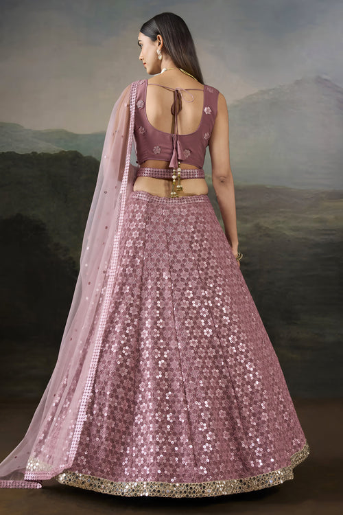 Back view of the baby pink sangeet attire showing the tie-up back blouse, long net dupatta and flared sequinned georgette skirt.