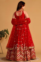 Full-length back view of a red lehenga for wedding with an open back choli with dori tie and zari and sequin embroidery.