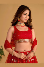 Close-up view of a red engagement dresses for women lehenga with detailed zari and sequin embroidery throughout work on the choli.