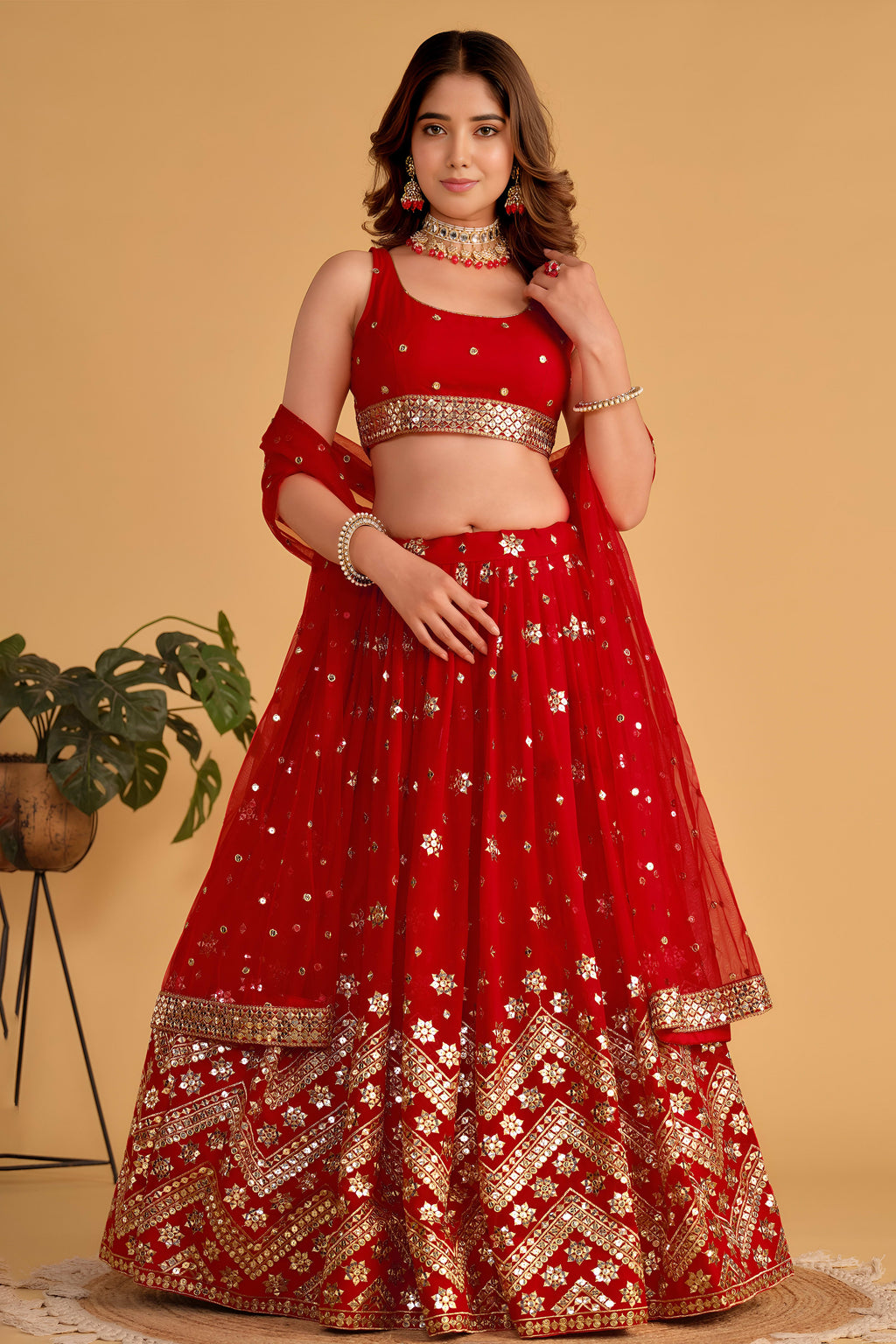 Woman wearing a red lehenga for wedding with zari and sequin embroidery, sleeveless round neck choli, full-length front view.
