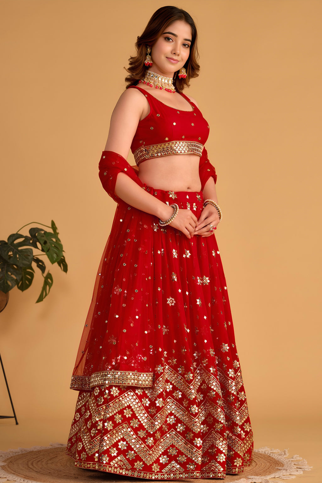 Full-length side view of a red lehenga for wedding with zari and sequin embroidery throughout on the flared lehenga skirt.