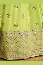 Detail view of a neon yellow sangeet lehenga showing intricate zari and sequin embroidery throughout on the lehenga skirt border.