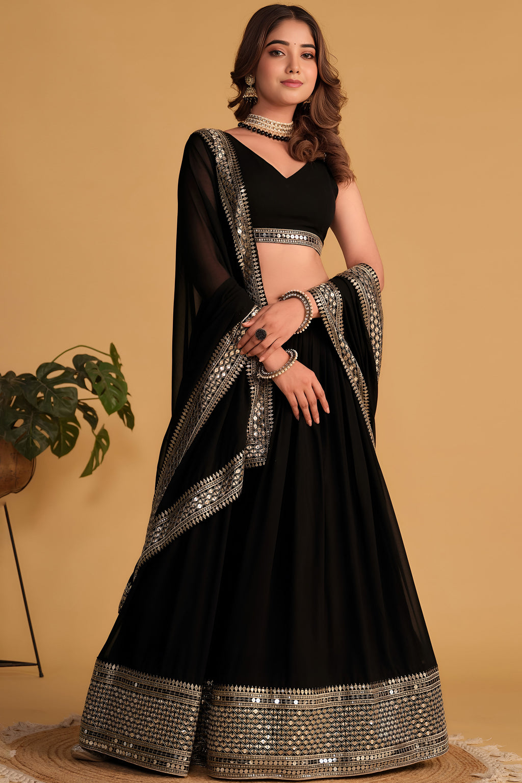Full-length back view of a black reception lehenga with V neckline back choli and zari and sequin embroidery throughout work.