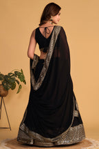 Full-length side view of a black reception lehenga with zari and sequin embroidery throughout on the flared lehenga skirt.
