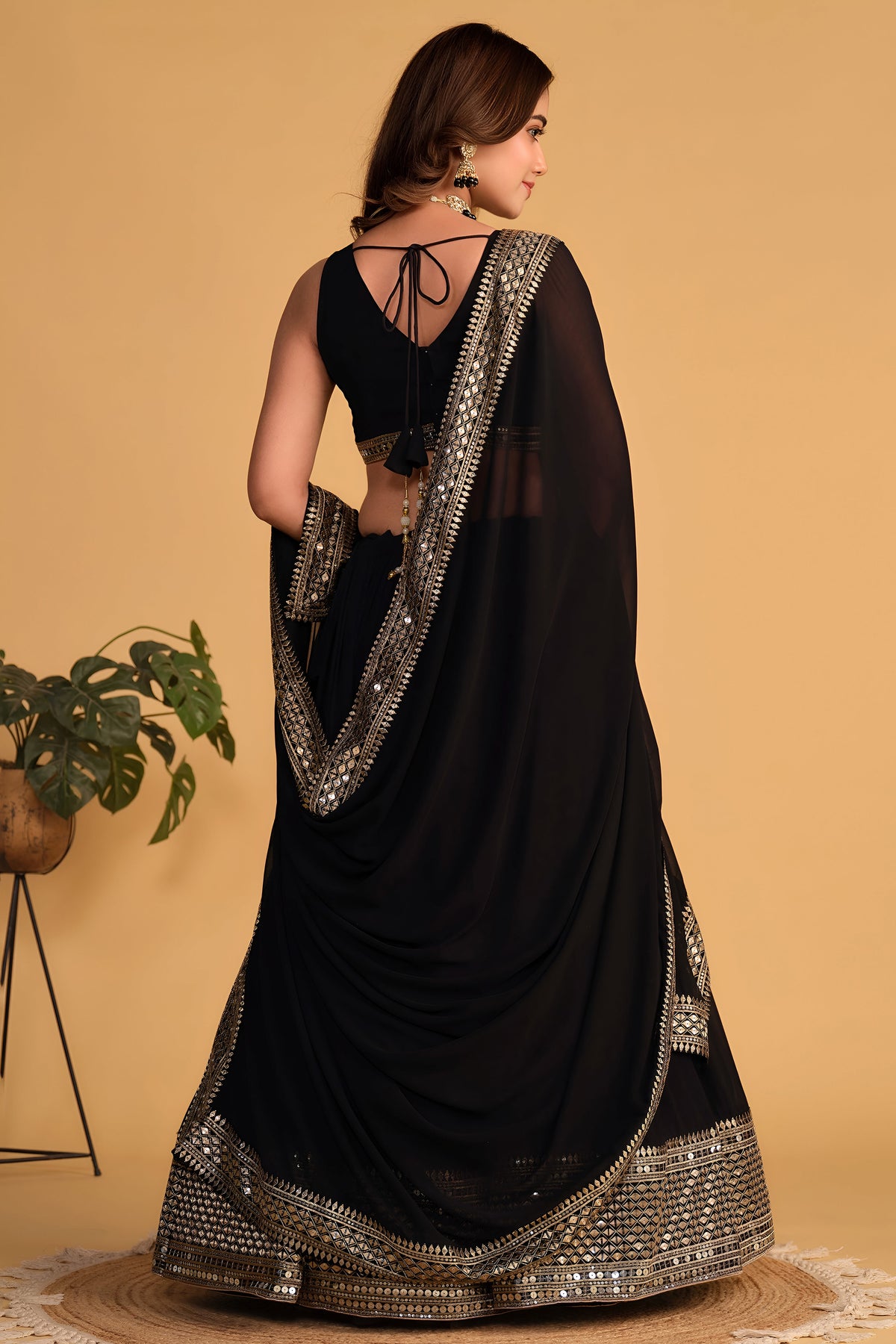 Full-length side view of a black reception lehenga with zari and sequin embroidery throughout on the flared lehenga skirt.