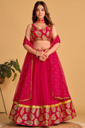 Woman wearing a reddish pink sangeet lehenga with zari and sequin embroidery, sleeveless sweetheart neck choli, full-length front view.