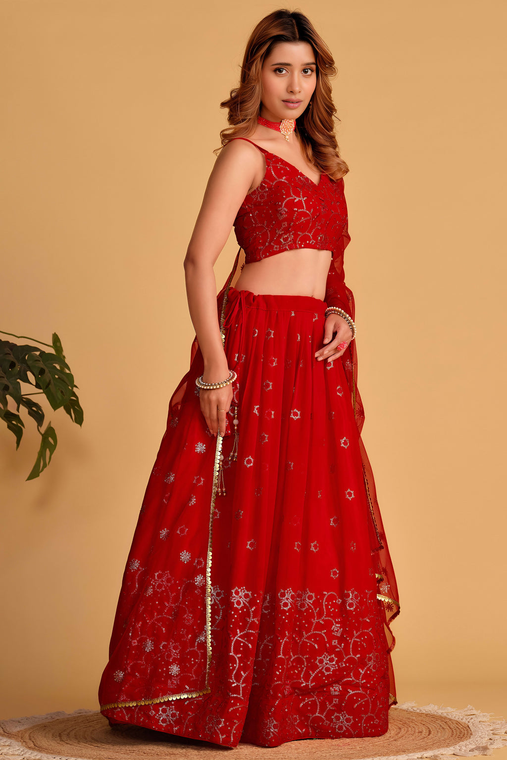 Additional view of a reddish pink reception lehenga with zari and sequin embroidery throughout the outfit, sleeveless choli.