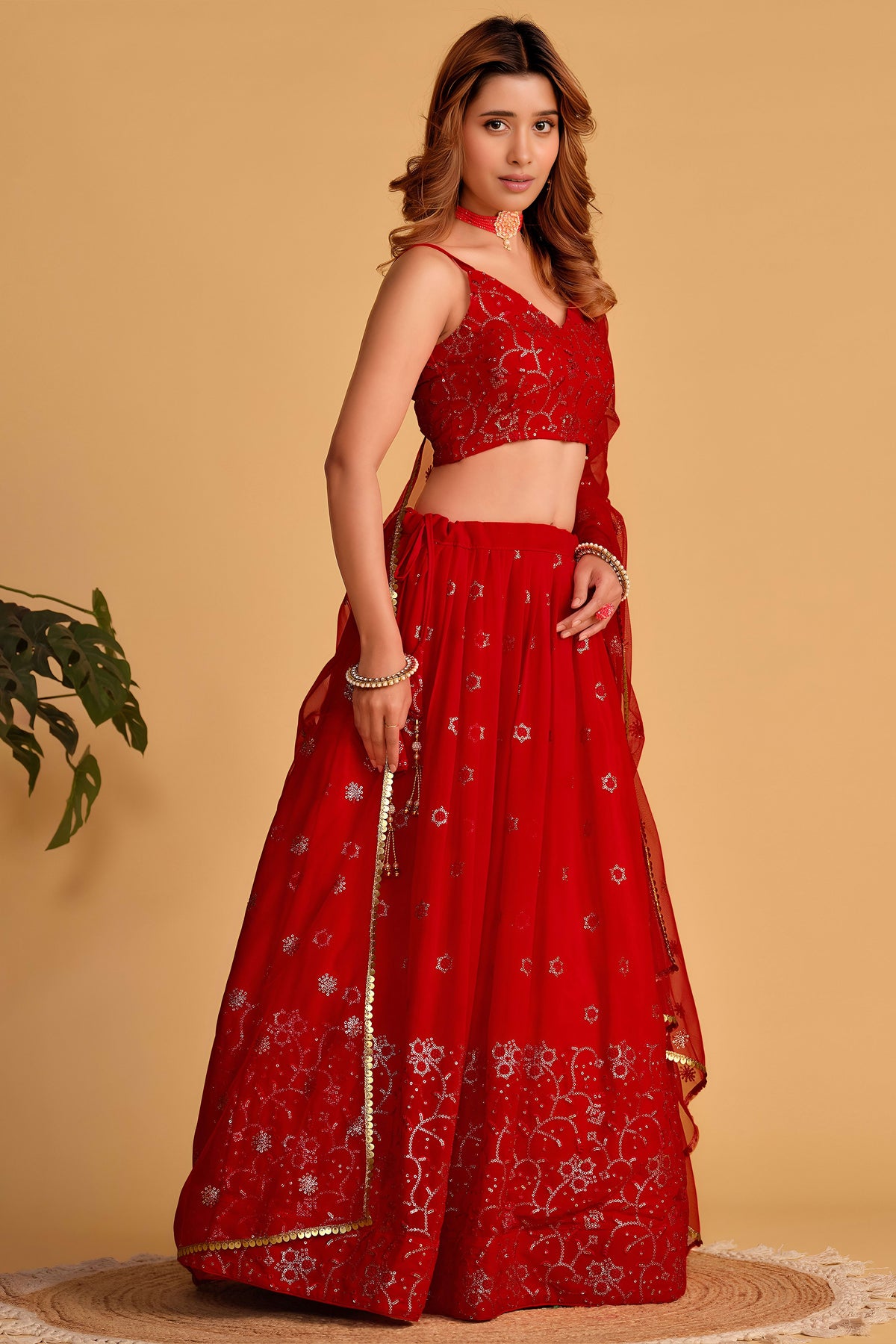 Additional view of a reddish pink reception lehenga with zari and sequin embroidery throughout the outfit, sleeveless choli.