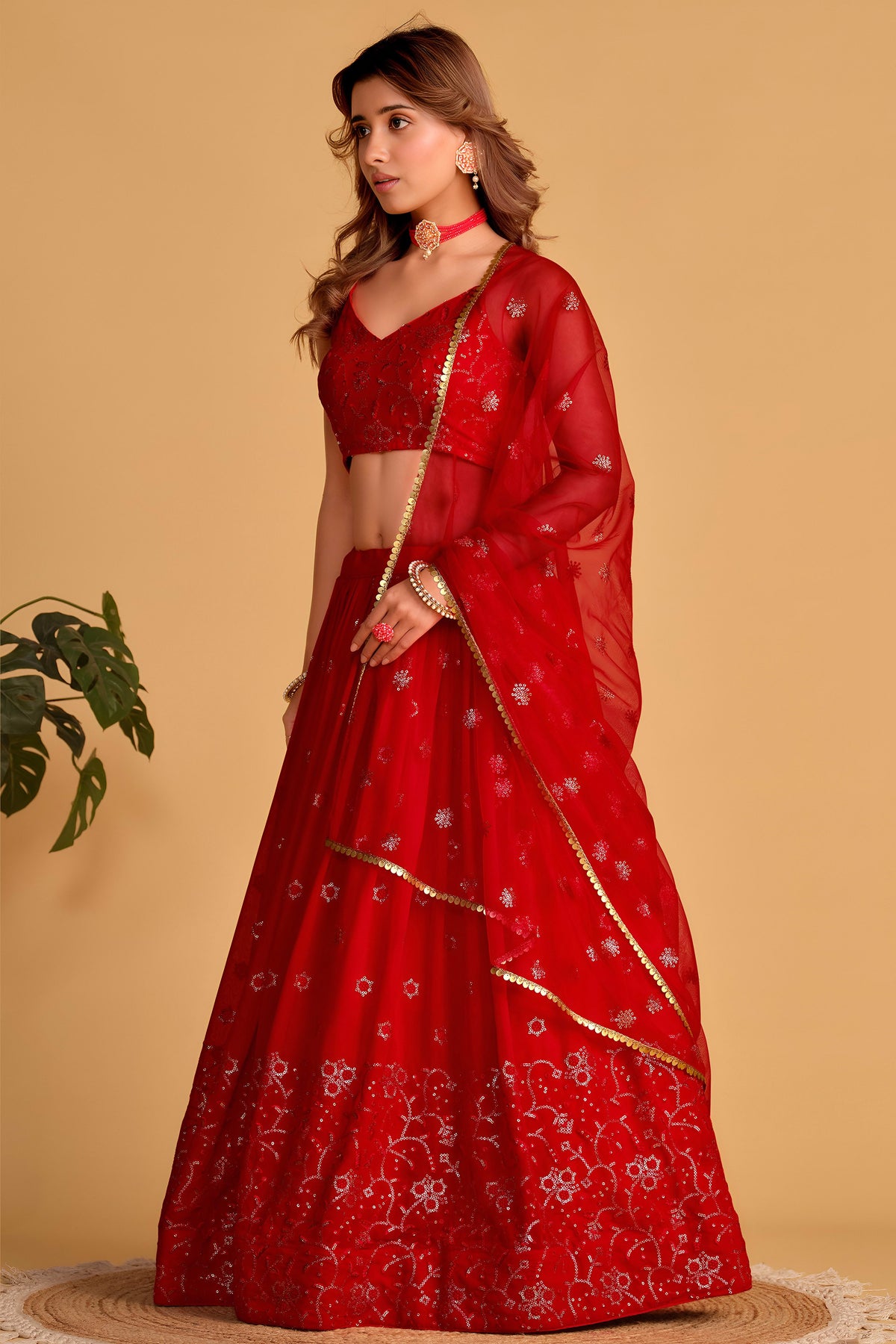 Full-length back view of a reddish pink engagement lehenga with square neckline back choli and zari and sequin embroidery work.