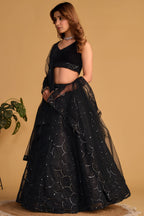Alternate full-length view of a black sangeet lehenga with zari and sequin embroidery on the sleeveless velvet choli and lehenga.