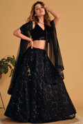Full-length back view of a black cocktail lehenga with V neckline back velvet choli and zari and sequin embroidery work.