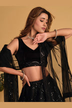 Close-up view of a black engagement dresses for women lehenga with detailed zari and sequin embroidery on the velvet choli.