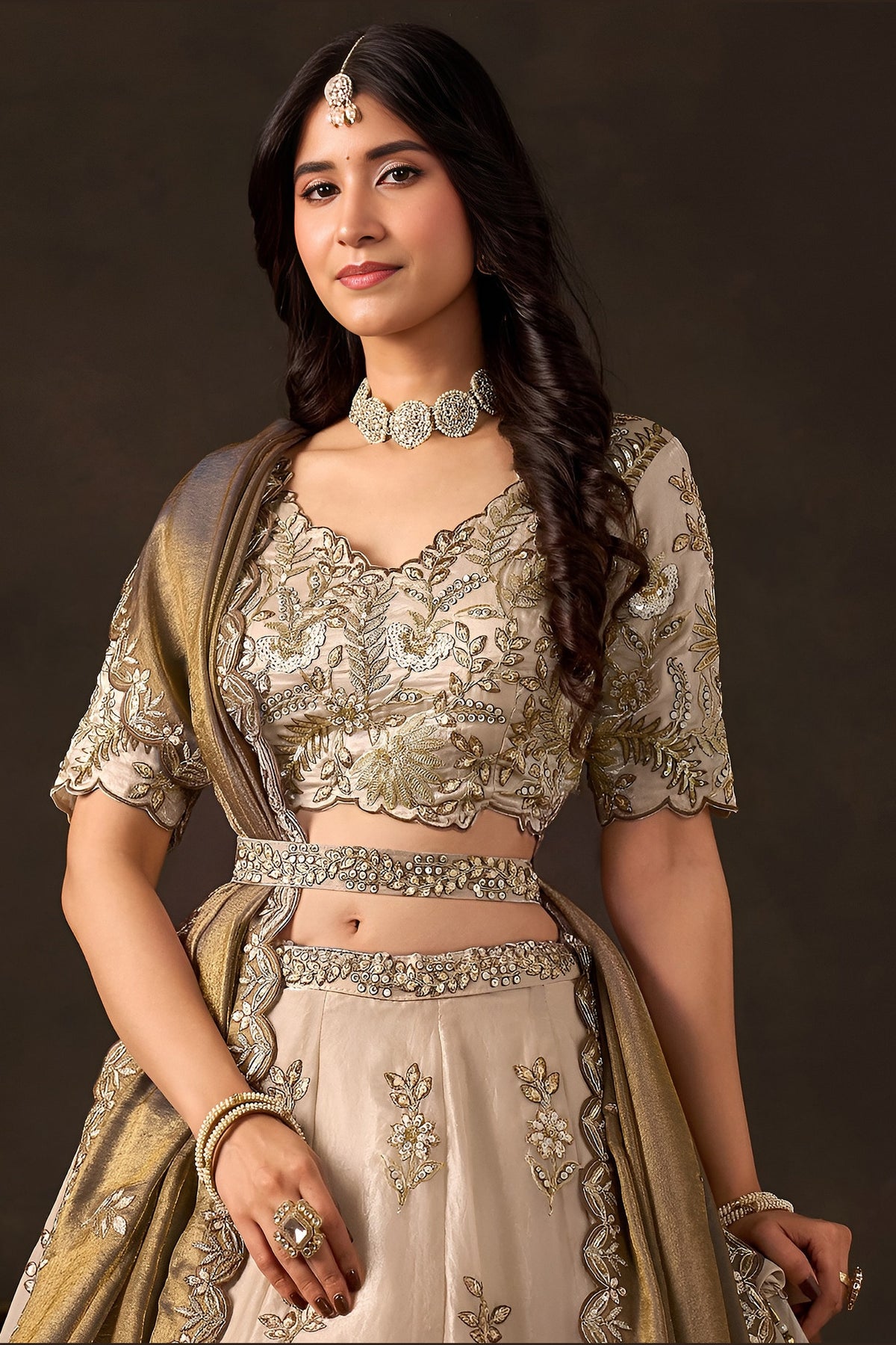Light beige reception lehenga choli on model, side view displaying flared skirt with embroidery.