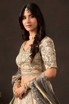 Light beige silk lehenga choli flat lay, embroidered skirt panels with zari motifs.