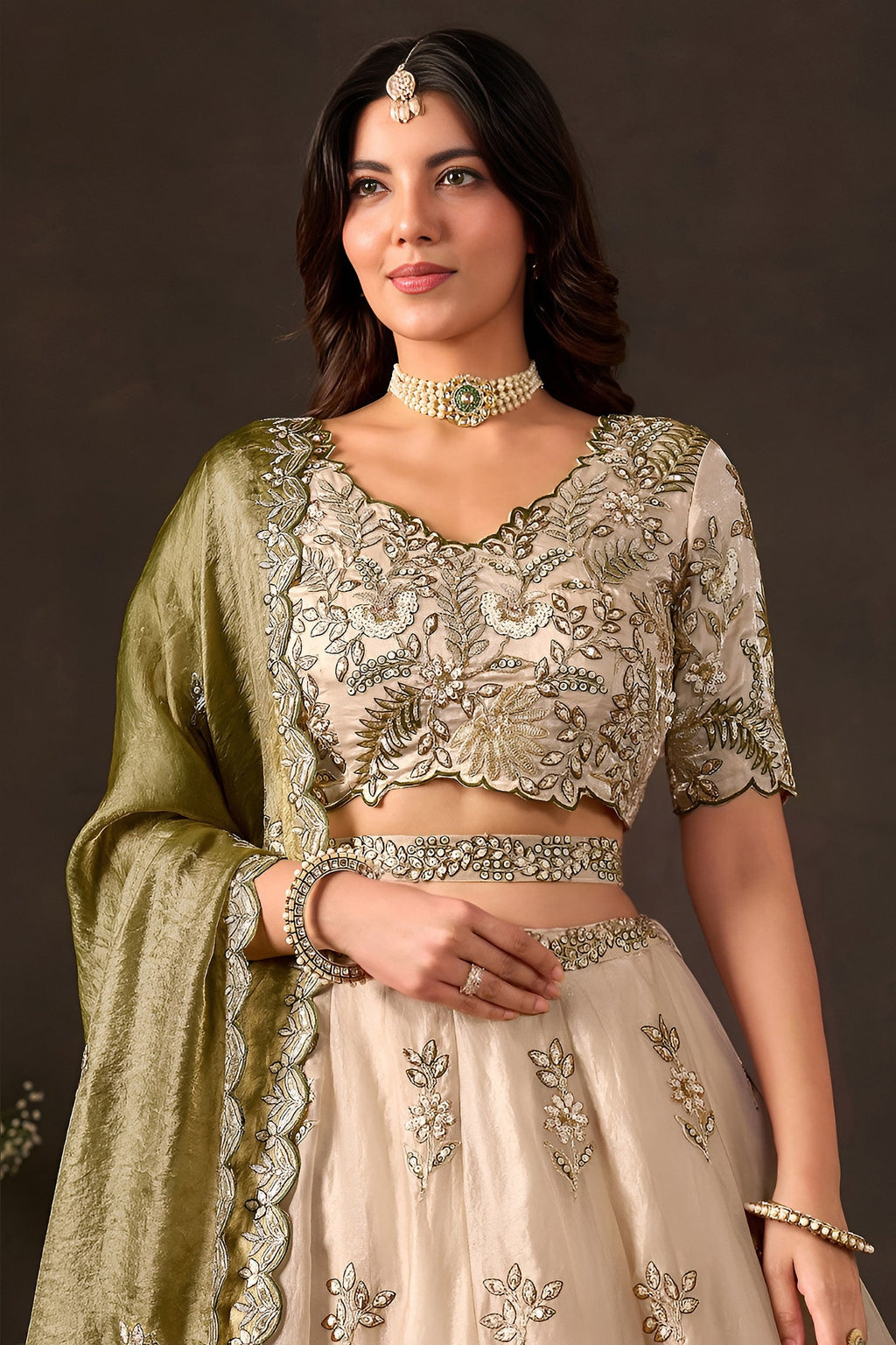 Light beige indian lehenga choli on model, side view displaying flared skirt embroidery.