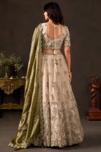 Light beige lehenga choli for sangeet, three-quarter front view, V neckline blouse with zari work.