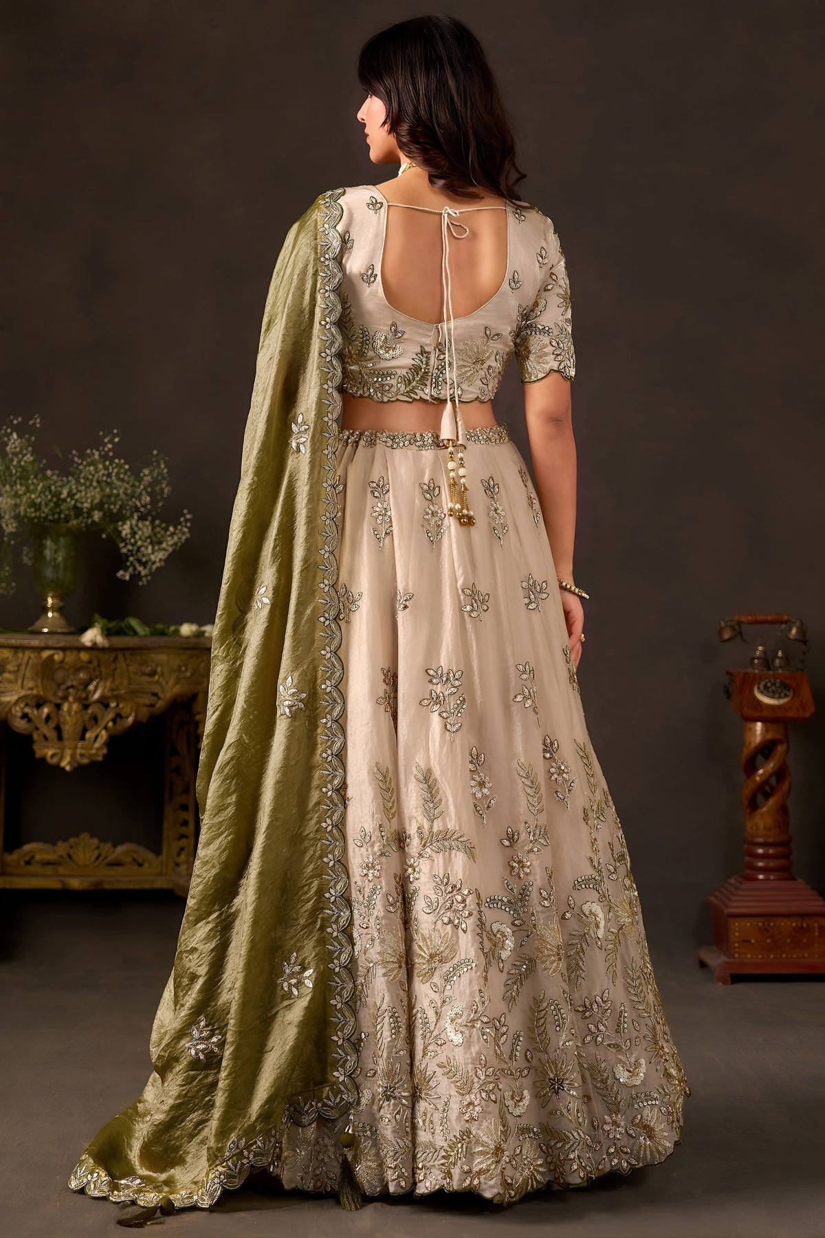 Light beige lehenga choli for sangeet, three-quarter front view, V neckline blouse with zari work.