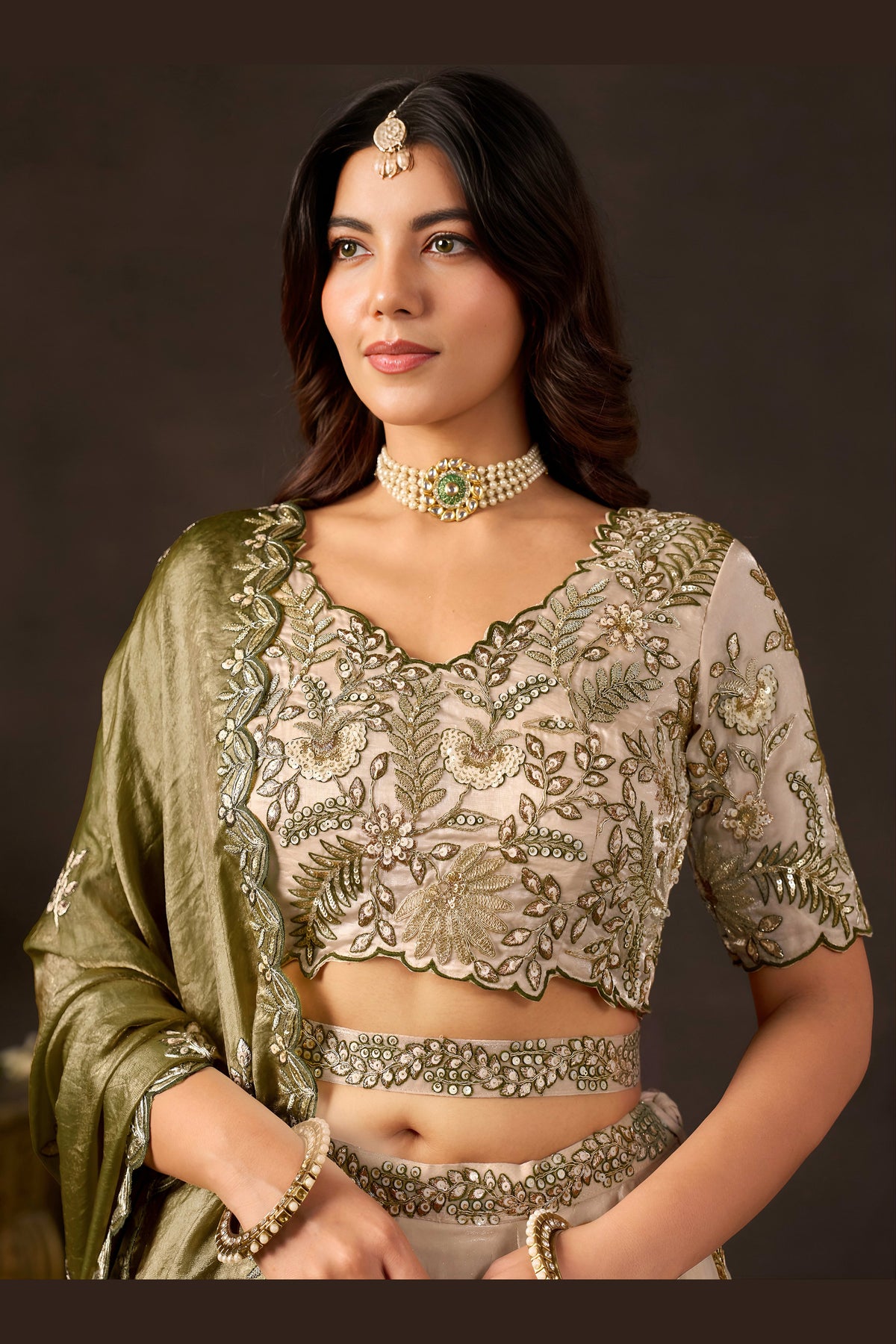 Detail of light beige lehenga choli dupatta edge, zari and sequin border.