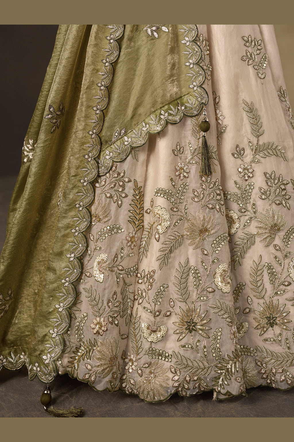 Light beige sangeet lehenga choli with fendy silk dupatta, full length view on model.