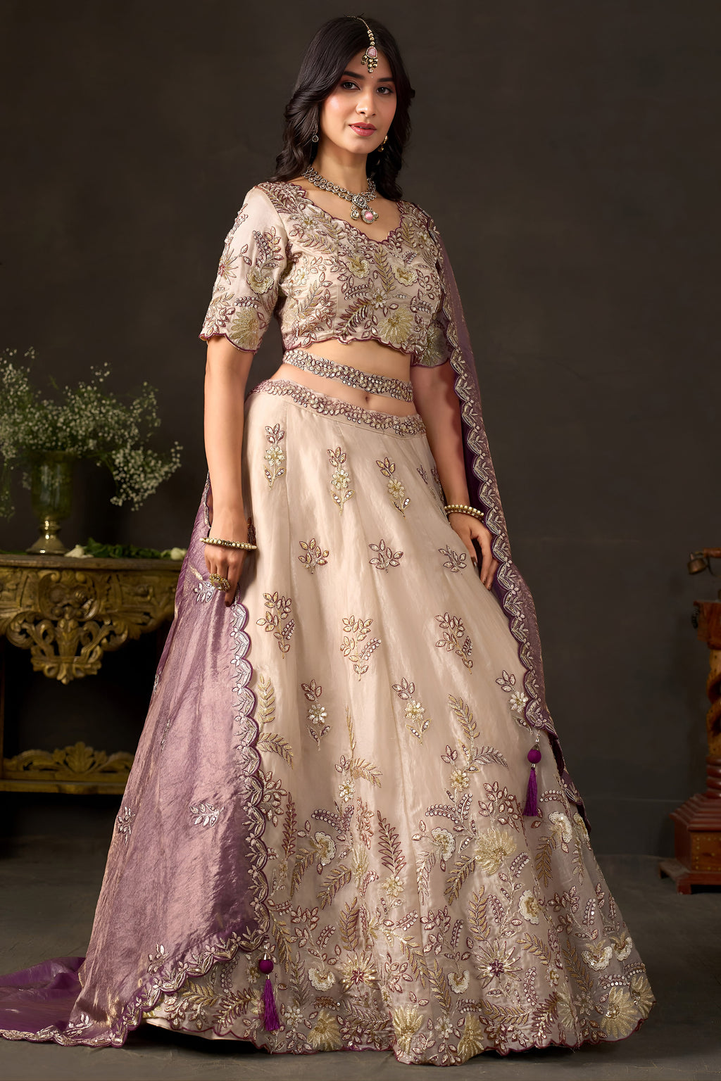 Light beige wedding guest lehenga flat lay, skirt panels with zari floral motifs.